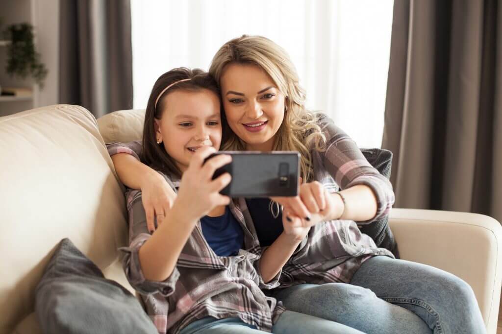 Modern parenting of young mother with her little daughter